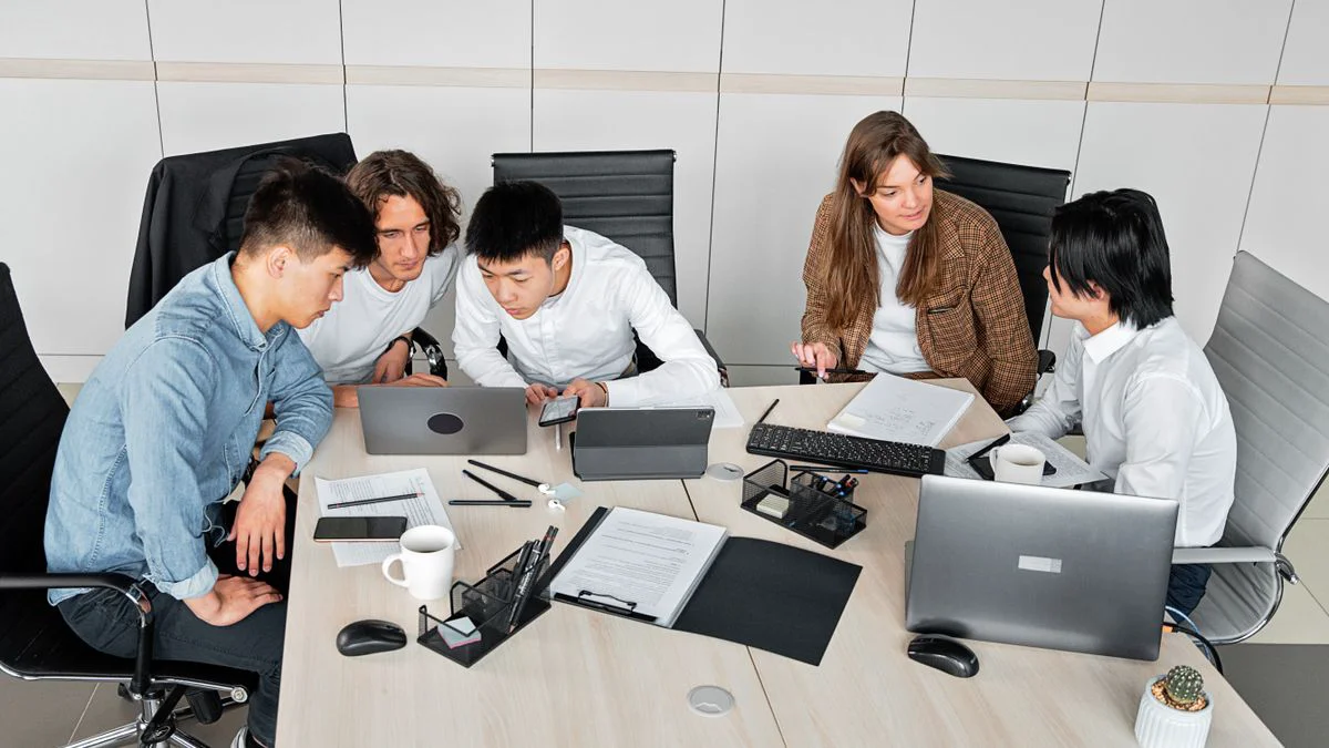 Colleagues discussing product information beside an open laptop