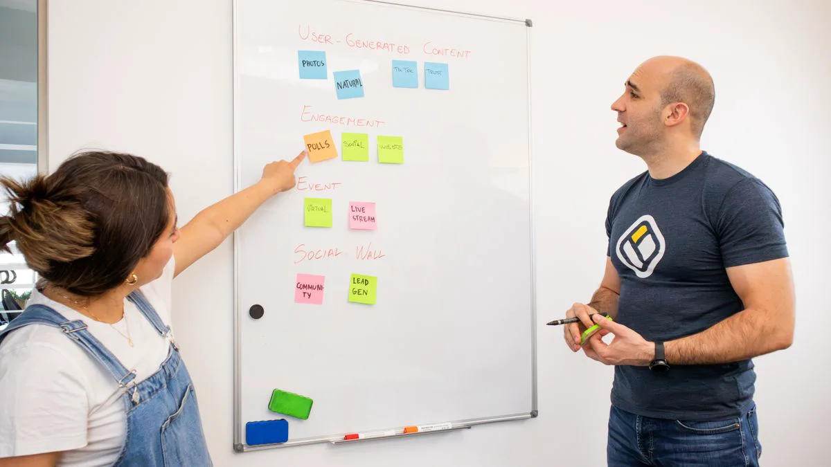 A small team planning website content with sticky notes and laptops