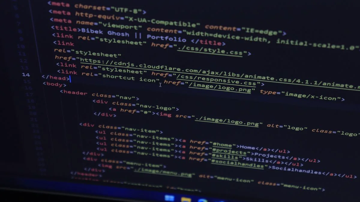 Developer working at a computer with code visible on the screen