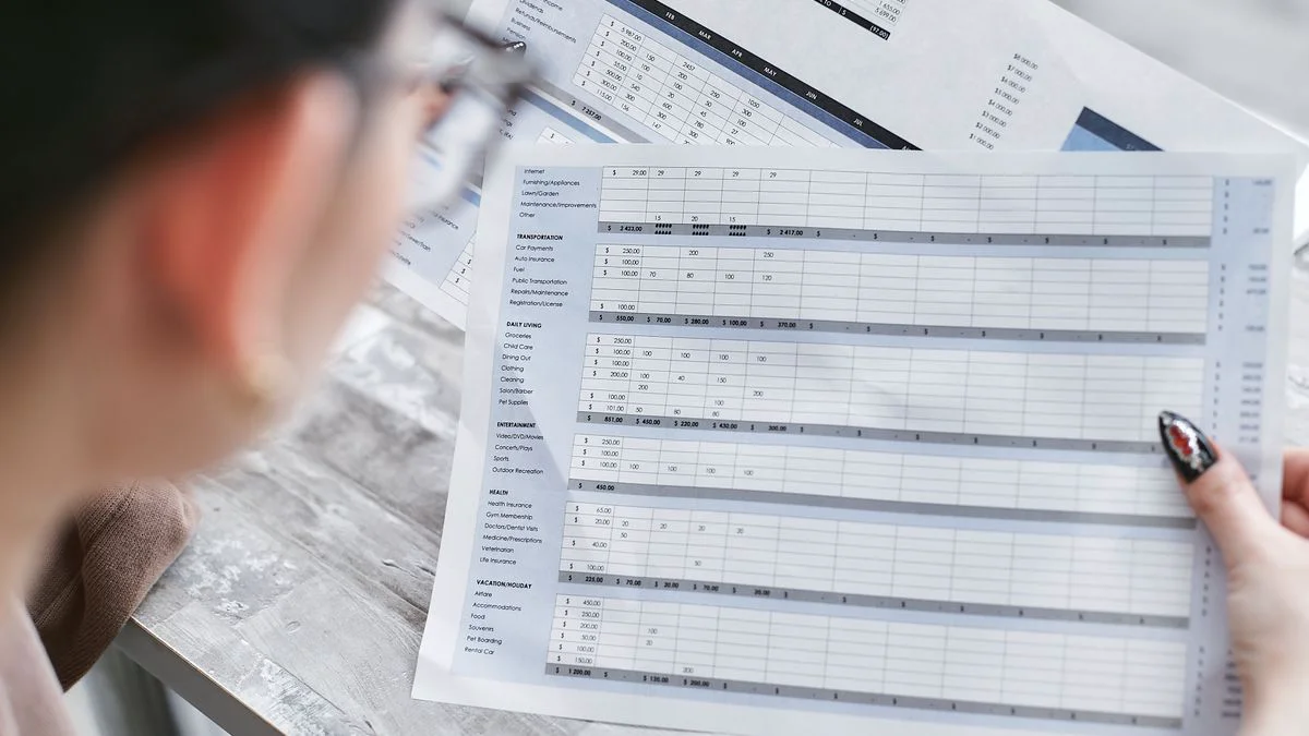 A laptop showing a planning spreadsheet with weekly production numbers