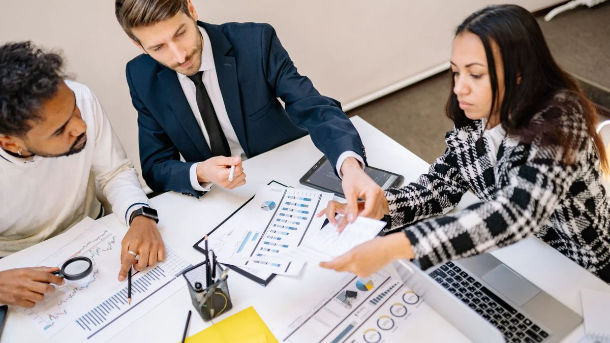 Two colleagues comparing growth options on a conference table with notes and charts