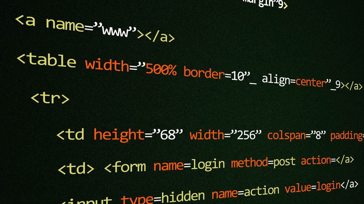 A developer workspace with code on a monitor and notes beside a keyboard
